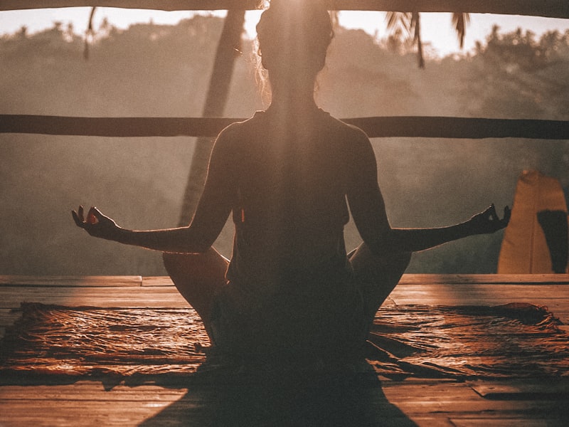 Person meditating at sunset
